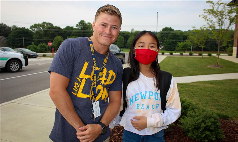 A student and teacher smile